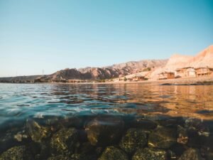 Clear shallow reef water along the coast below desert hills
