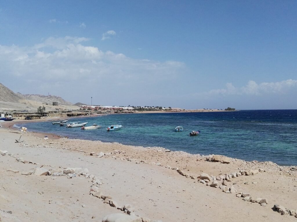 The Three Pools snorkelling spot south of Dahab, with boats on the shore
